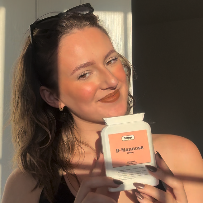 Supp Montmorency Cherry Extract laid on marble table with capsules next to it