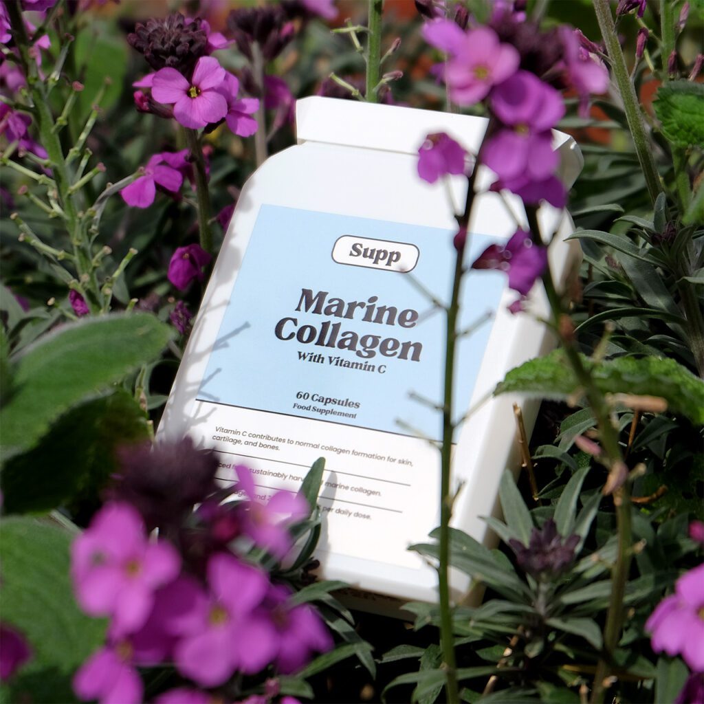 Supp Marine Collagen in a bed pink flowers.