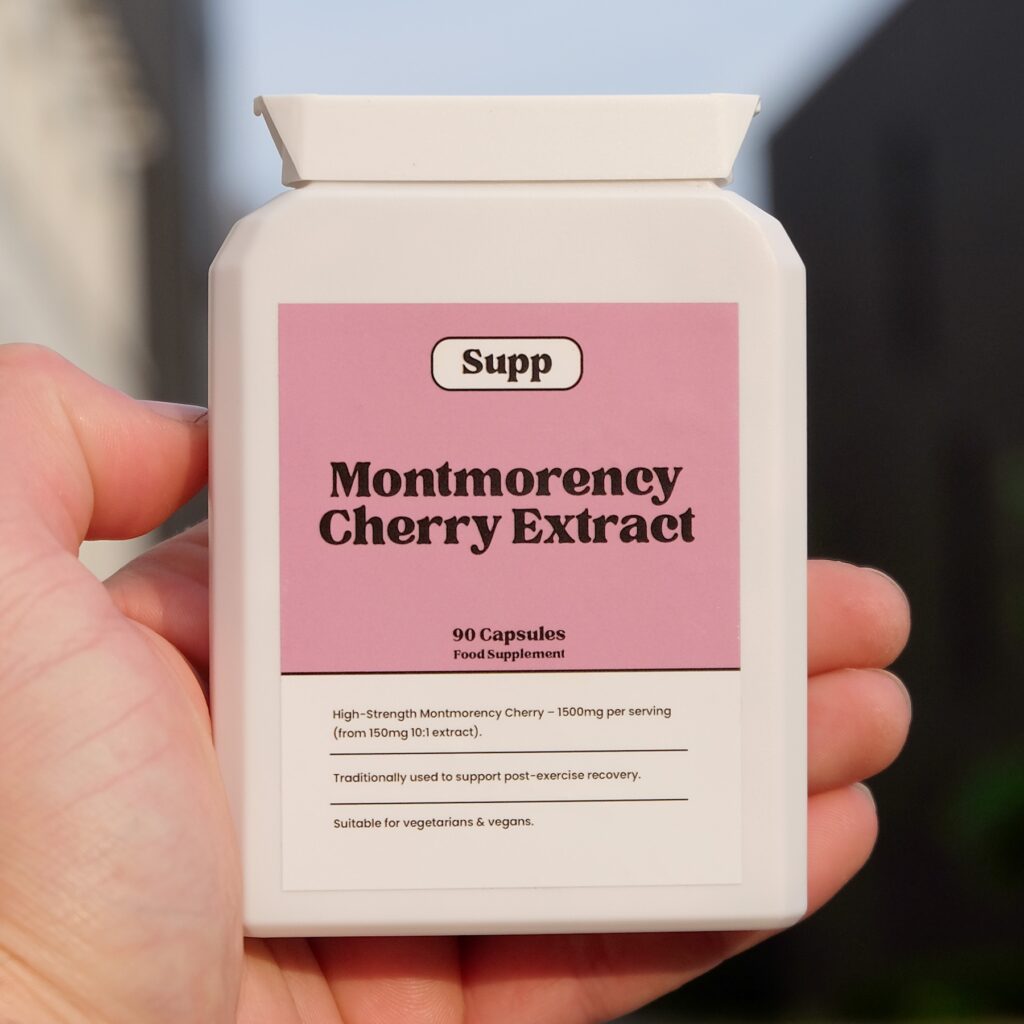 a hand is holding a bottle of Supp Montmorency Cherry Extract