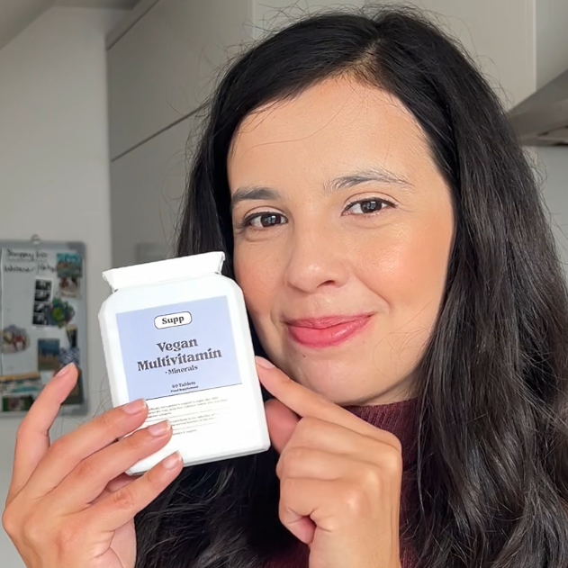 A young lady holding Supp Vegan Multivitamin.
