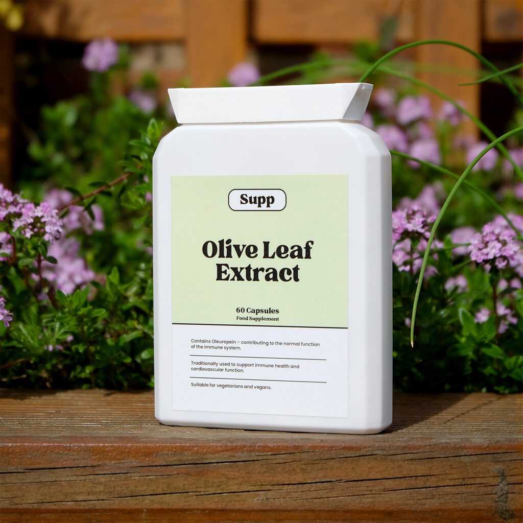 Supp Olive Leaf Extract stood up next to pink flowers.