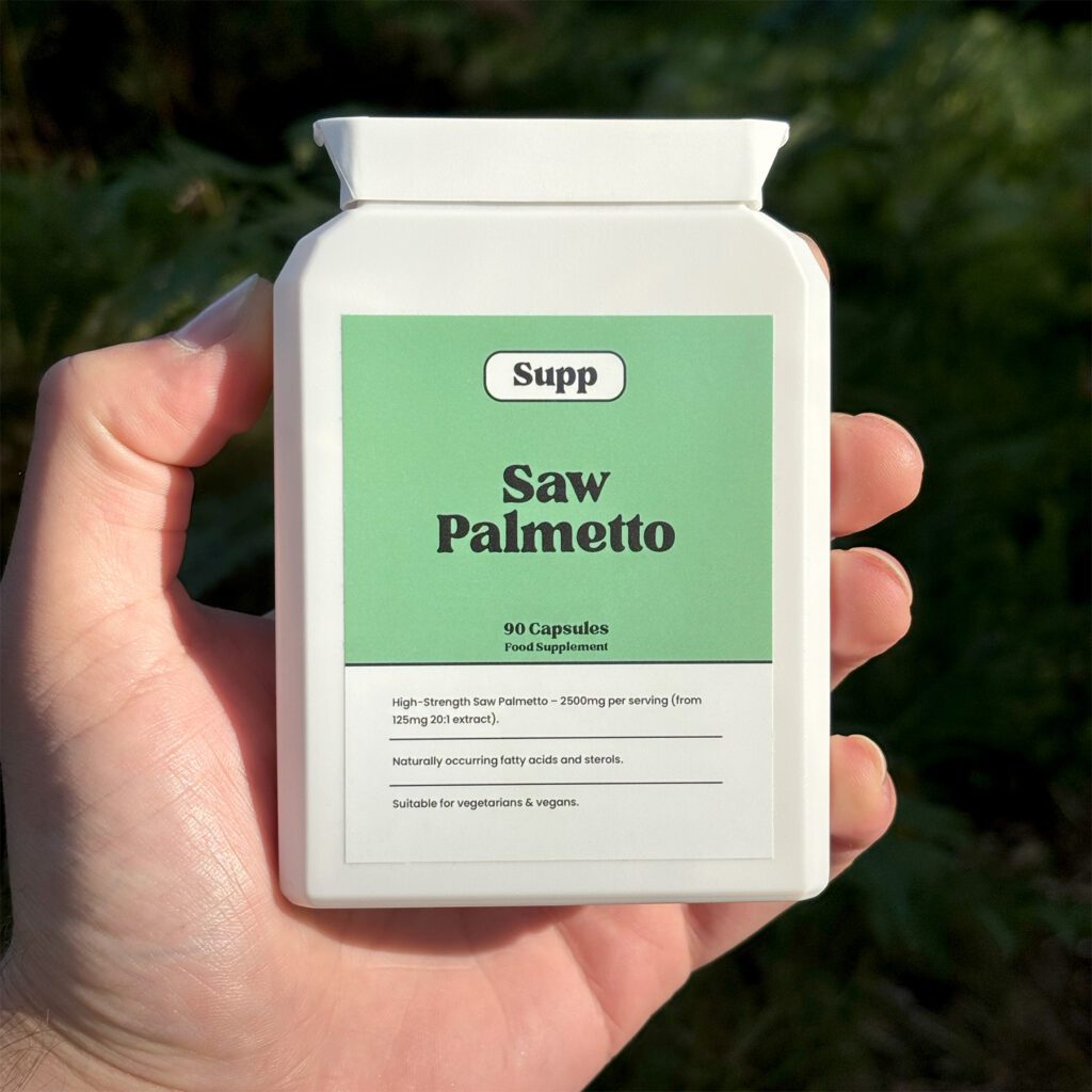 A male hand holds a bottle of Supp Saw Palmetto