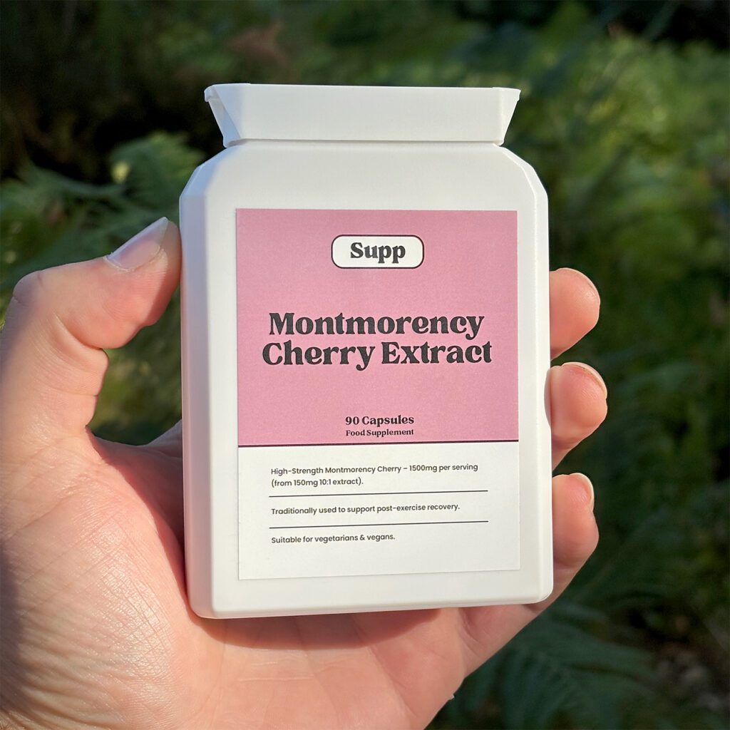 Supp Cherry Capsules being held outside against a blurred, green background
