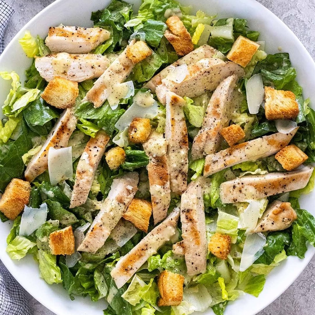 Chicken caesar salad in bright natural light.