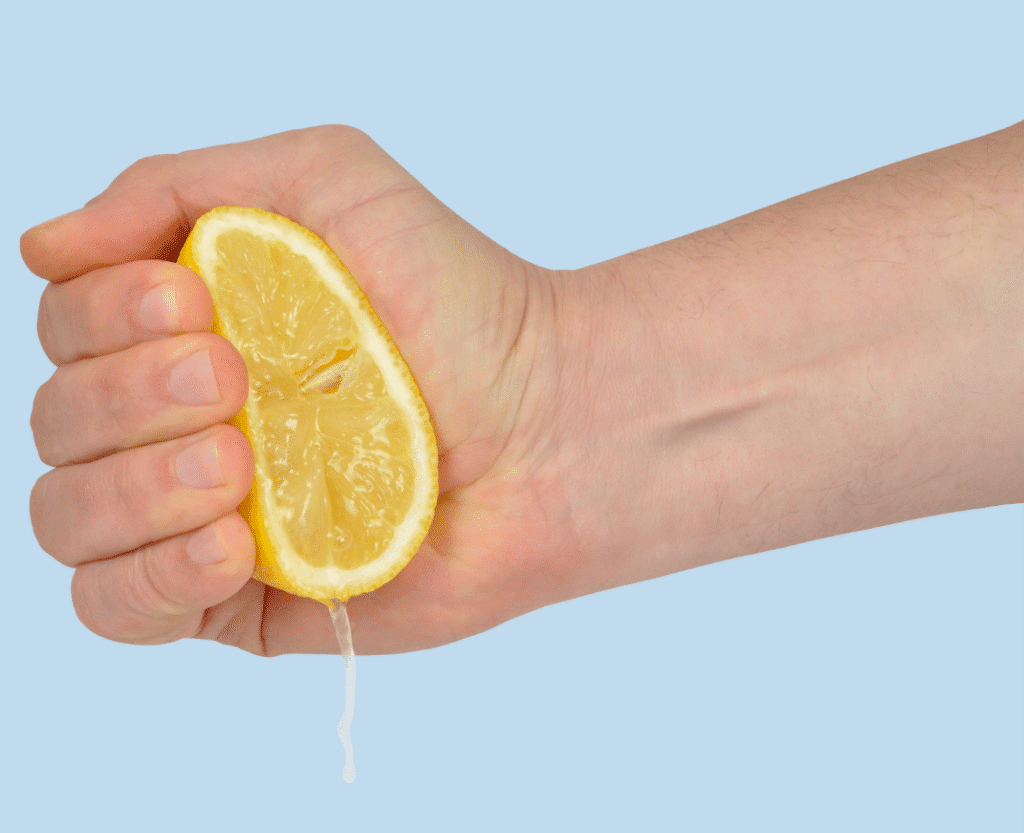 Hand squeezing a lemon.