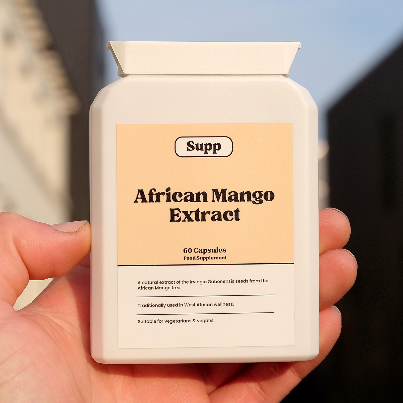 Supp African Mango Extract held up in a hand in sunset light.