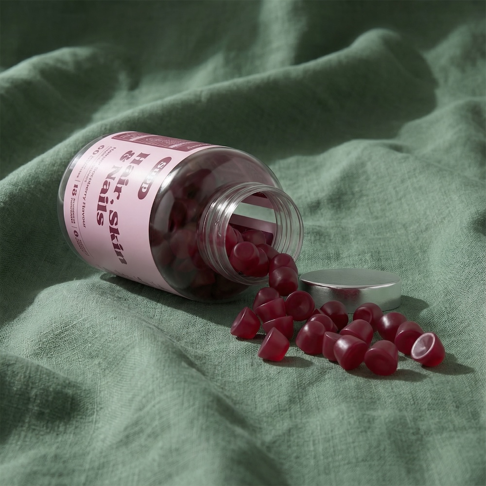 Supp Hair Skin And Nails Gummies on a sage green cloth.