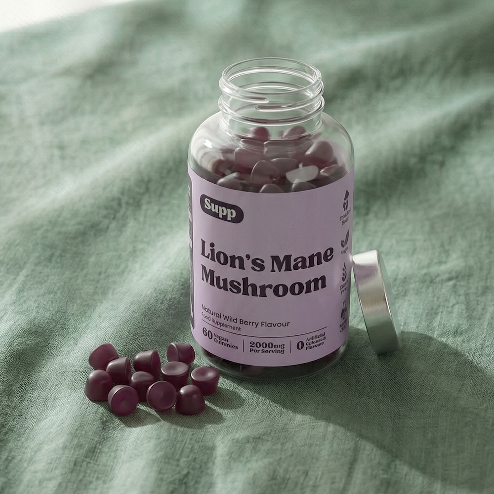 Lion's Mane Mushroom Gummies next to supplement bottle on a green cloth table.