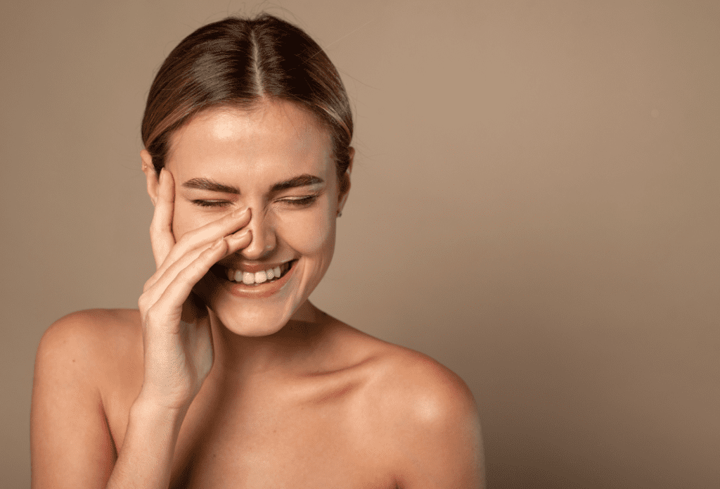 Woman with natural, healthy-looking skin against a neutral background
